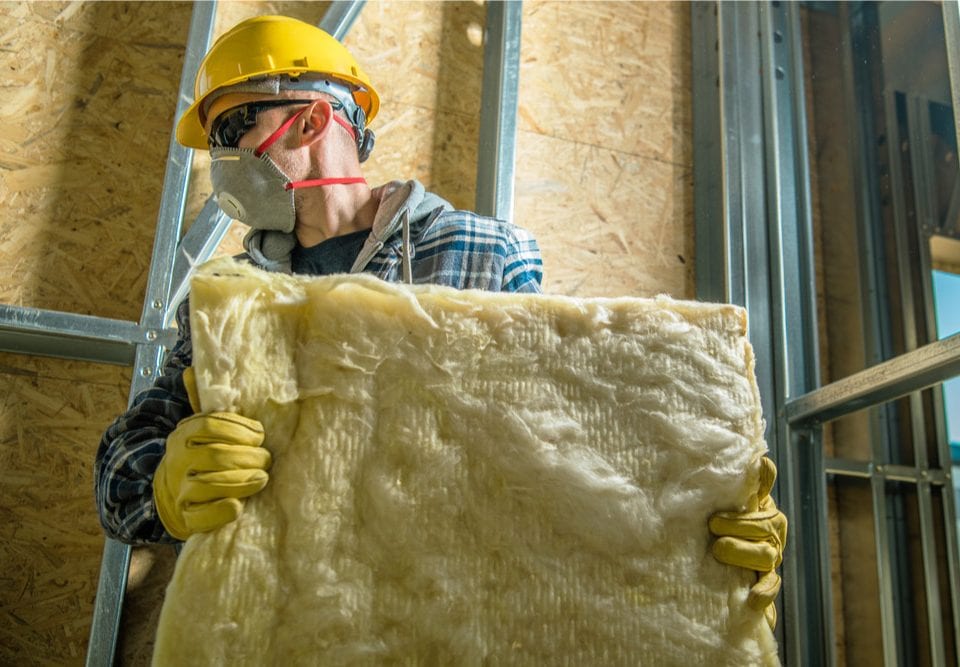 worker carrying a piece of thermal insulation