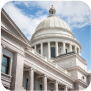 A view of the Arkansas Capitol building, highlighting its grand dome and impressive facade in a vibrant setting