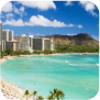 A scenic beach with soft waves, framed by a vibrant city skyline in the background